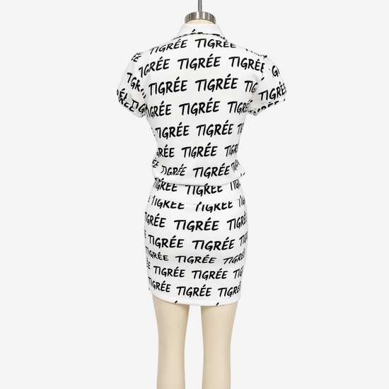 White dress with black text on a mannequin against a white background