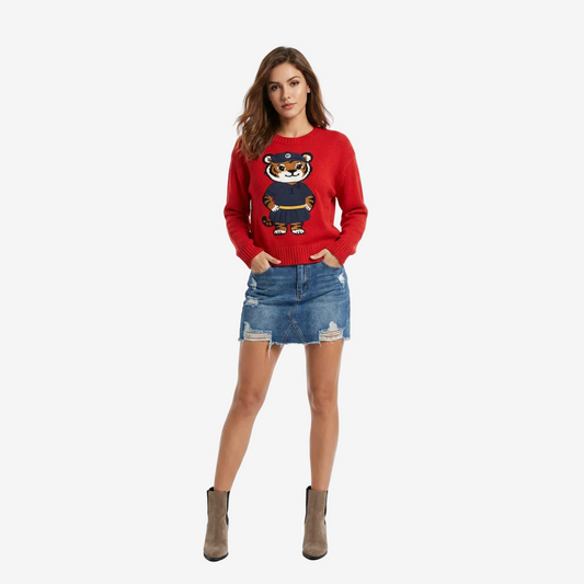 Woman wearing a red sweater with a tiger design and a denim skirt on a white background